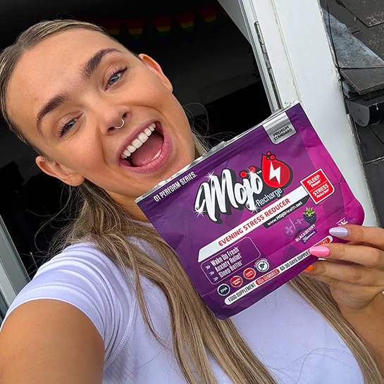 A customer holding a pack of MOJO™ RECHARGE sleep gummies